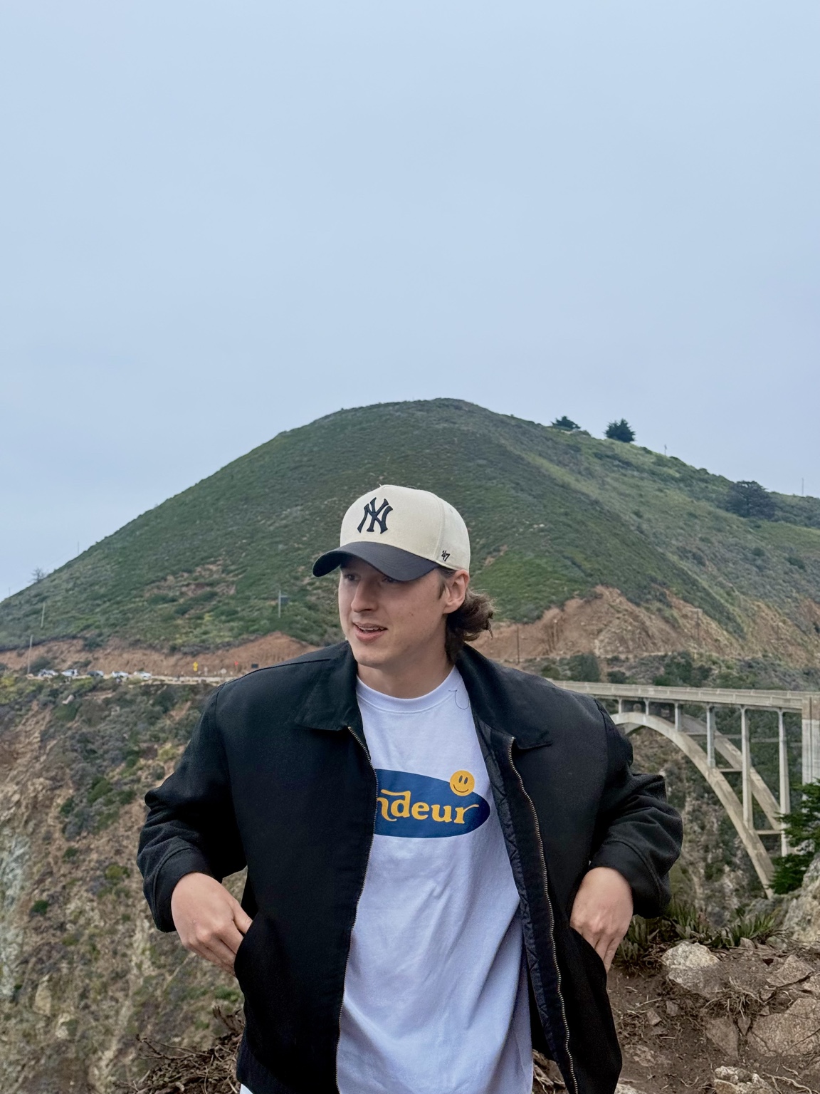 Ryan Underdown standing beside the coastal hills and Bixby Bridge